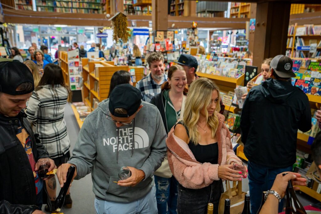 A large group of people waits in line at one of the Sip & Stroll stops. 