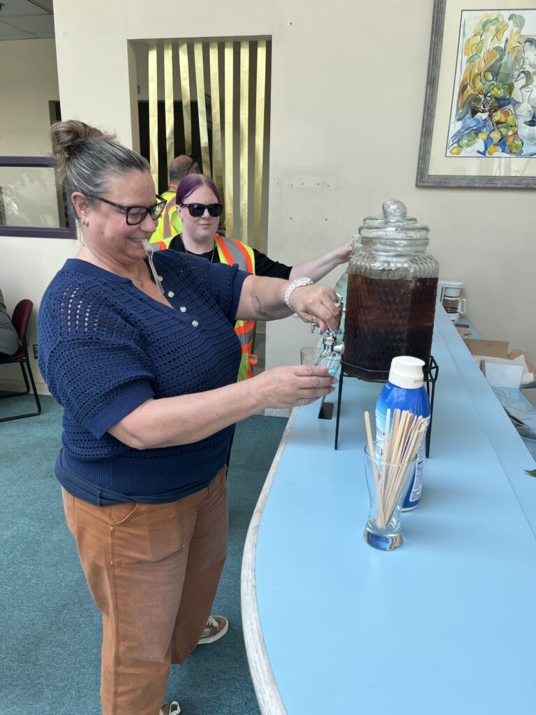 Garten employee filling up a glass with some delicious iced coffee. 