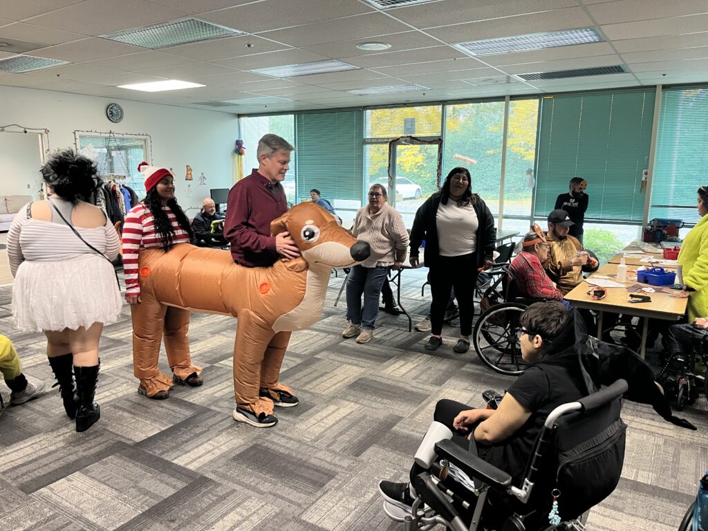 CEO Will Posegate and Ruth Fuentes enter daybreak in a 2-person dog costume.