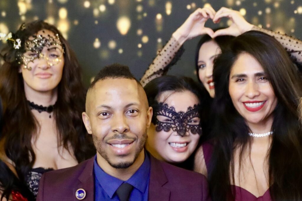 Charles Shambry Poses in a photo booth with other attendants at the Garten Gala.