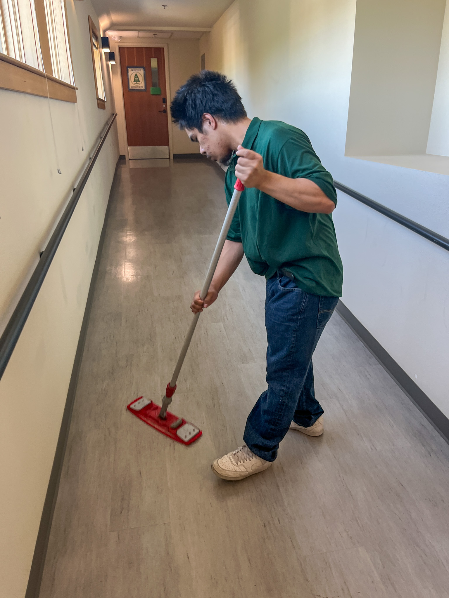 Custodial team mopping and polishing floors in a corporate workspace.